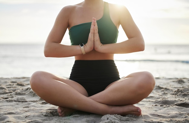 Femme yoga et méditation sur la plage pour un bien-être spirituel zen ou une séance d'entraînement en plein air