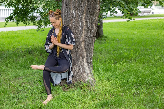 Femme yogi avec des dreadlocks pratiquant la pose de yoga