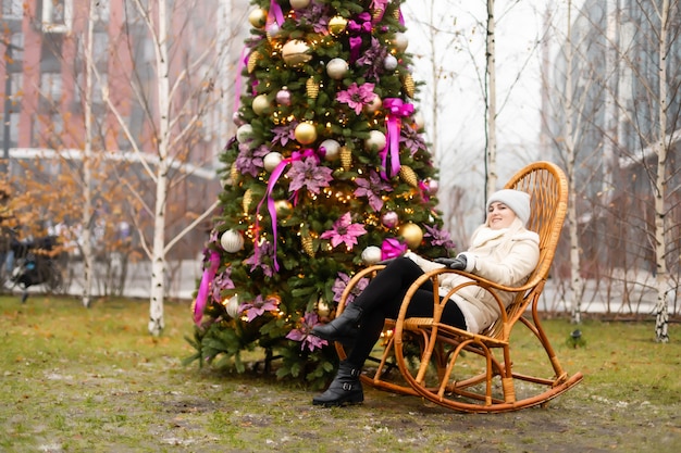 femme et zone photo arbre de noël et chaise berçante dans la rue