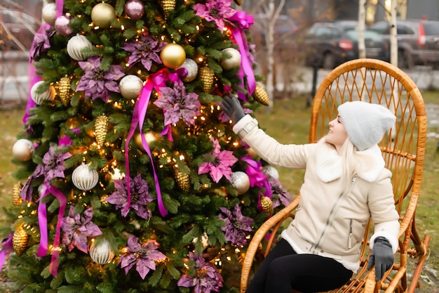 femme et zone photo arbre de noël et chaise berçante dans la rue