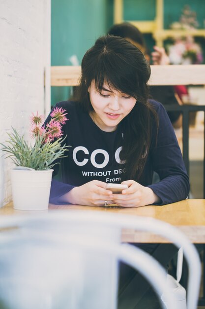 Femmes adolescentes asiatiques à l'aide de smartphone et souriant