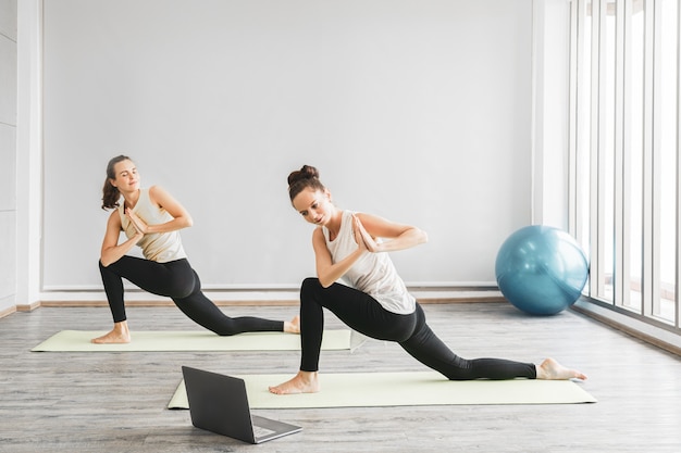 Femmes adultes pratiquant le yoga ensemble