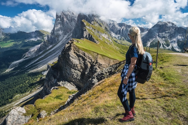 Les femmes adultes avec sac à dos profitez du paysage du pic de Seceda dans les Alpes Dolomites de la chaîne de montagnes Odle Sout
