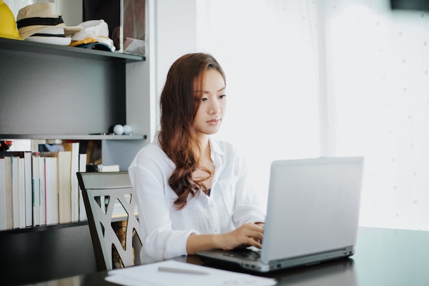 Femmes d&#39;affaires asiatiques à l&#39;aide de cahier et souriant heureux de travailler