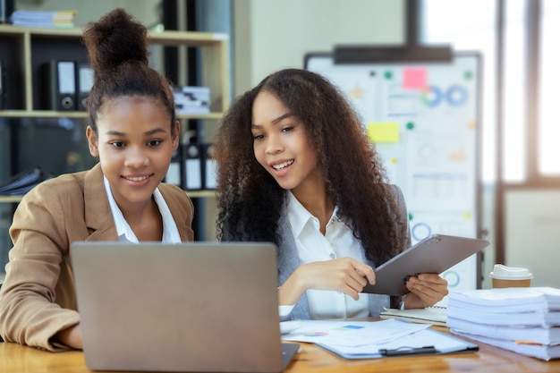 Photo des femmes d'affaires asiatiques discutant des revenus de performance lors d'une réunion d'affaires travaillant avec un conseiller financier de l'équipe de collègues analysant des données avec un investisseur