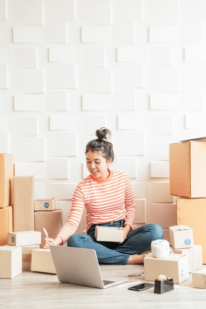 Femmes d'affaires asiatiques travaillant à la maison avec une boîte sur le lieu de travail