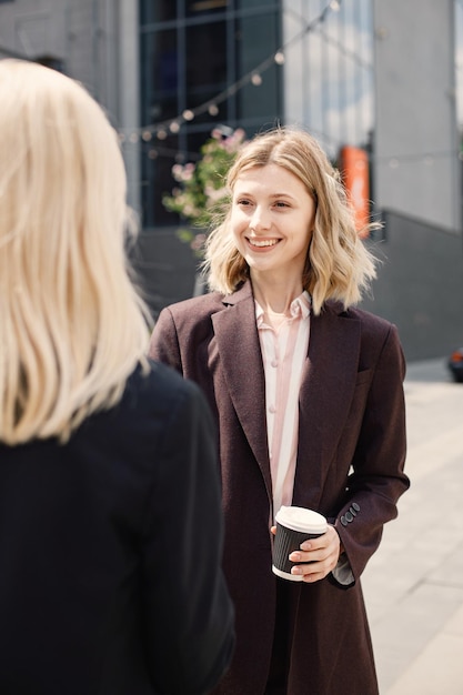 Femmes d'affaires debout et se parlent devant un bureau moderne