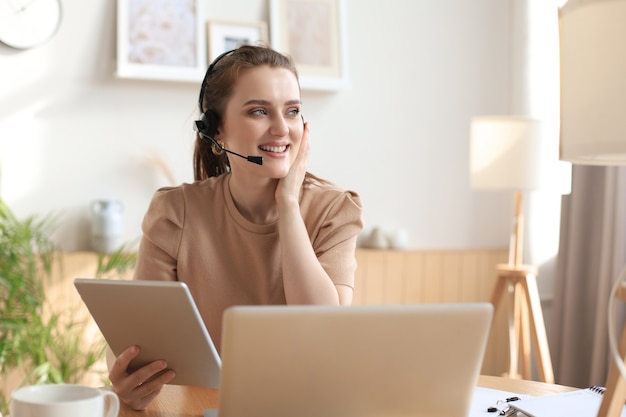 Femmes d'affaires indépendantes utilisant une tablette de travail par vidéoconférence avec un client sur le lieu de travail à la maison.