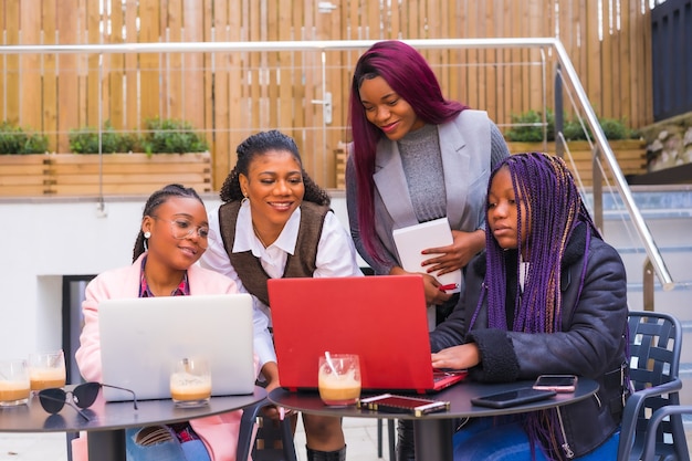 Femmes d'affaires jeunes et alternatives d'ethnie noire. En réunion de travail d'équipe, dans une cafétéria