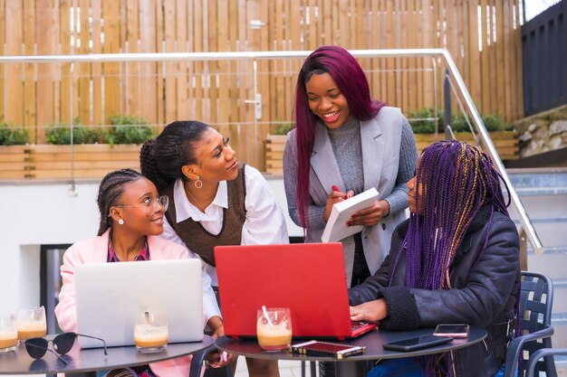 Femmes d'affaires jeunes et alternatives d'ethnie noire. En réunion de travail d'équipe, dans une cafétéria