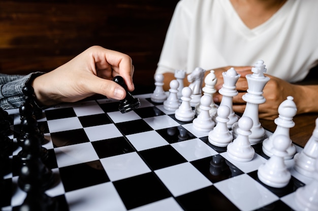 Les femmes d'affaires jouent aux échecs à bord défient la planification d'une stratégie commerciale pour réussir le concept