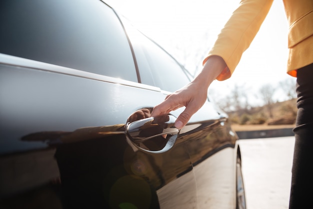 Femmes d'affaires ouvrant la porte d'une voiture noire