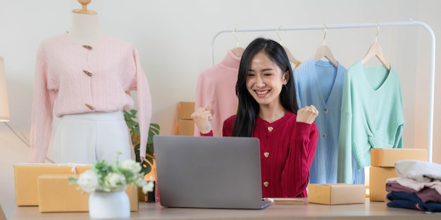 Les femmes d'affaires des PME asiatiques utilisent un ordinateur portable pour vérifier les boîtes d'expédition en ligne des commandes des clients à la maison