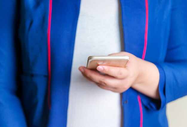 Femmes d'affaires avec smartphone mobile sur fond flou, réseau technologique et banque en ligne et banque en ligne et concept de personnes en réseau