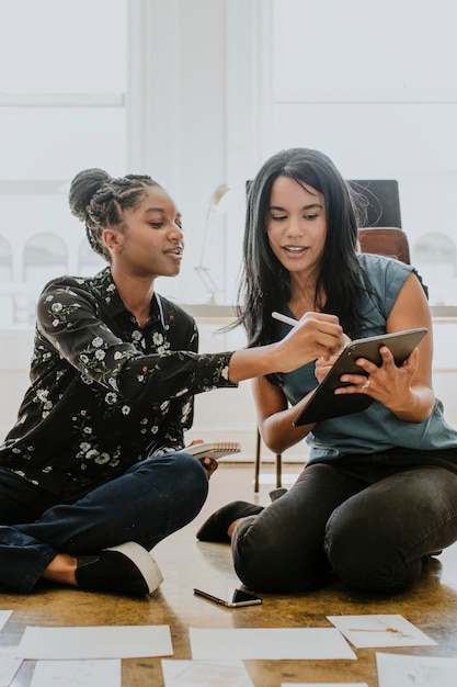 Femmes d'affaires travaillant ensemble à l'aide d'une tablette numérique