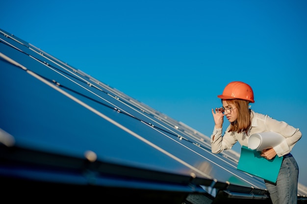 Les femmes d'affaires travaillant sur la vérification de l'équipement à la centrale solaire avec liste de contrôle de la tablette