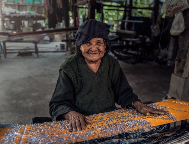 Des femmes âgées manifestent à la procédure de fabrication du tissage de la soie thaïlandaise