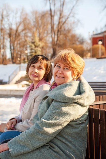 Femmes âgées occasionnelles contemplatives assises sur un banc dans un parc de printempsxDxAxDxA