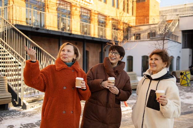 Les femmes âgées passent du temps ensemble tout en prenant un café à l'extérieur