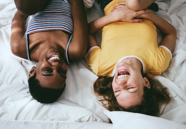 Photo femmes allongées sur le lit et riant