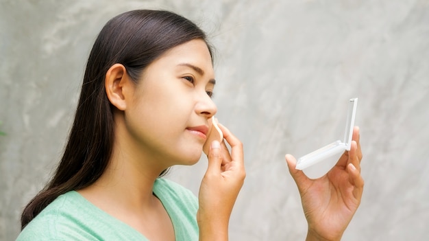 Les femmes asiatiques à appliquer de la poudre pressée.