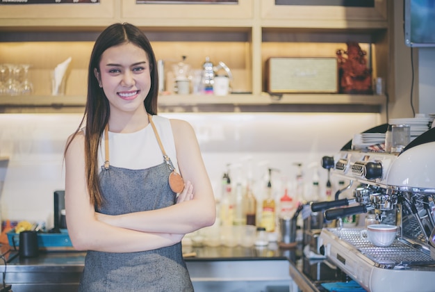 Femmes asiatiques Barista souriant et utilisant la machine à café dans le café-restaurant