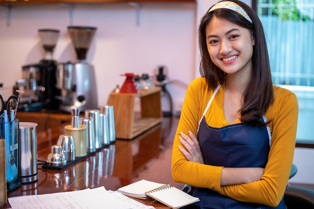 Femmes asiatiques Barista souriant et utilisant une machine à café dans un comptoir de café