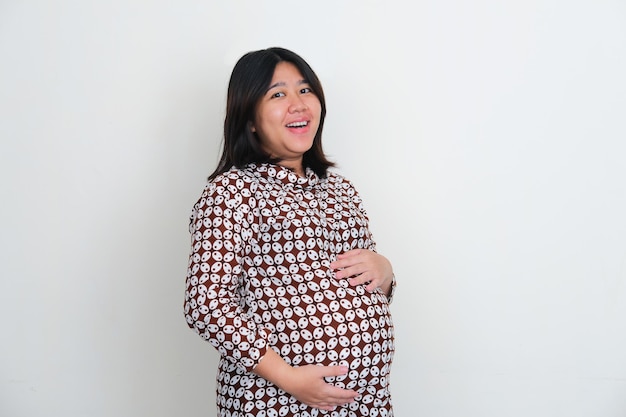 Femmes asiatiques enceintes souriant à la caméra tout en touchant son ventre