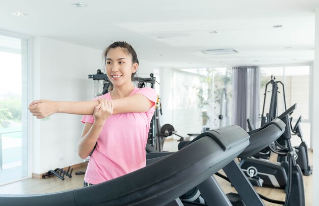 Les femmes asiatiques font de l'exercice dans la salle de sport pour passer au crible l'eau du cuir, gardant leur corps en bonne santé. Photo Premium