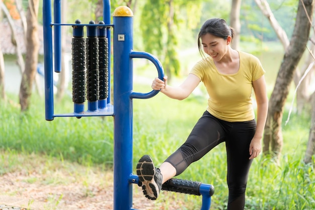 Les femmes asiatiques font de l'exercice en utilisant des installations d'amusement dans les parcs Le concept d'exercice sain et de prendre soin d'eux-mêmes