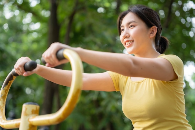 Les femmes asiatiques font de l'exercice en utilisant des installations d'amusement dans les parcs Le concept d'exercice sain et de prendre soin d'eux-mêmes