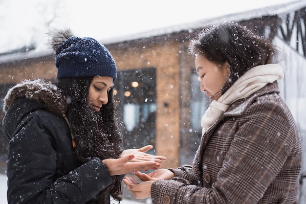 Photo des femmes asiatiques heureuses profitent d'une journée enneigée en hiver.