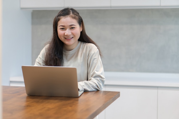 Les femmes asiatiques heureuses travaillent à domicile pendant l'épidémie.