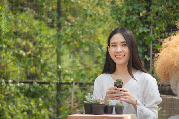 Les femmes asiatiques de jardinage à domicile cactus dans le jardin d'accueil