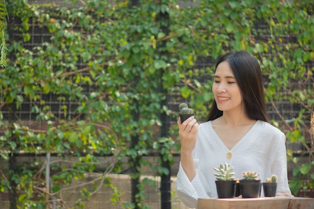 Les femmes asiatiques de jardinage à domicile cactus dans le jardin d'accueil