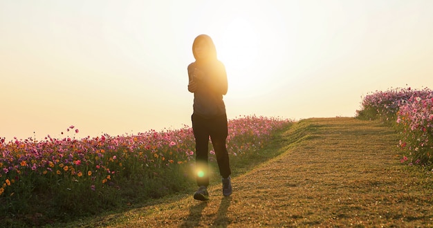 Femmes asiatiques, jogging le matin au champ de fleurs de cosmos