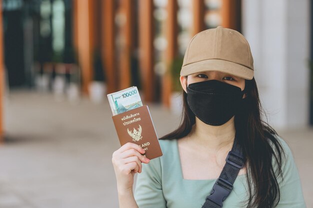 Femmes asiatiques avec masque chirurgical noir détenant des billets de banque du Laos kip argent la monnaie nationale de La