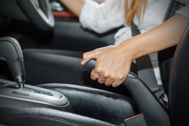 Les femmes asiatiques sont le frein à main et la voiture de frein de stationnement