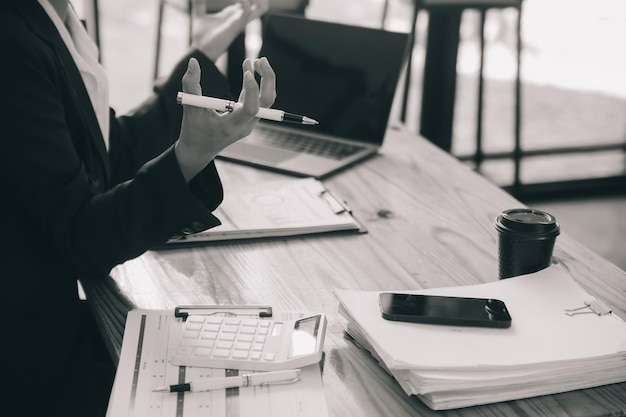 Les femmes asiatiques sont stressées en travaillant sur leur ordinateur portable. Une femme d'affaires asiatique fatiguée avec des maux de tête au bureau se sent malade au travail.
