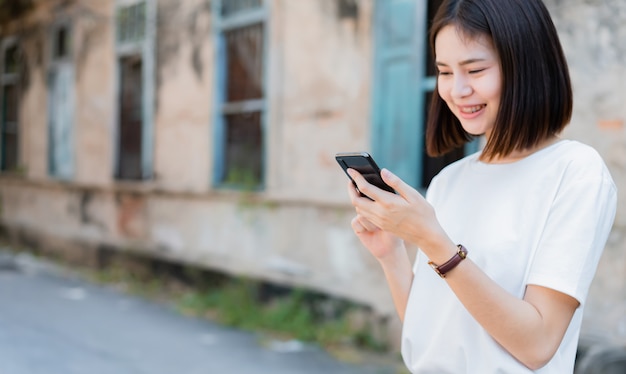 Femmes asiatiques de sourire heureux et à l&#39;aide de smartphone.