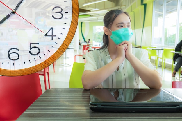 Les femmes asiatiques travaillent hors du bureau dans les aires de restauration des centres commerciaux portant des masques pour rester en sécurité et vivre dans la nouvelle normalité en compétition contre la date limite