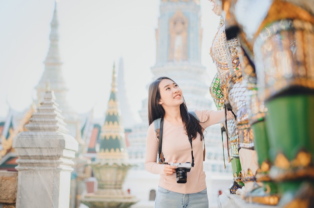 Les femmes asiatiques voyagent avec caméra tourisme dans le temple en Thaïlande