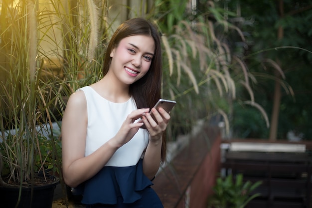 Les femmes d&#39;Asie sourient et utilisent la vérification mobile