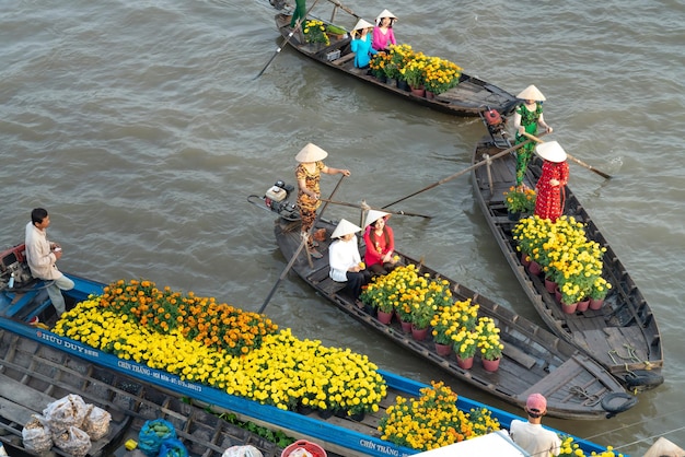 Des femmes assises sur des bateaux à rames avec des fleurs Photo