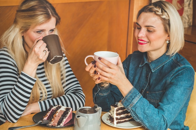 Les femmes assises dans un café et boivent un thé chaud