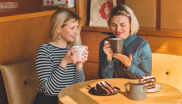 Les femmes assises dans un café et boivent un thé chaud