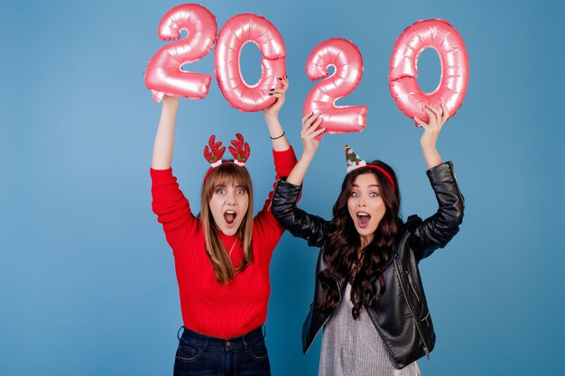 Femmes avec des ballons de nouvel an portant des cerceaux de Noël drôles