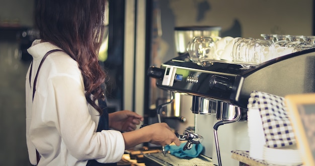 femmes Barista utilisant la machine dans le café-restaurant