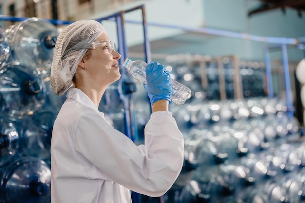 femmes blanches adultes heureuses travailleuses dans une usine d'eau potable boivent de l'eau propre