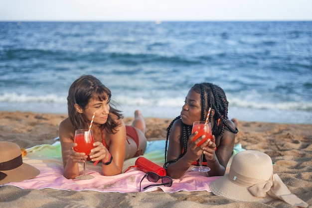 Femmes buvant des cocktails sur la plage